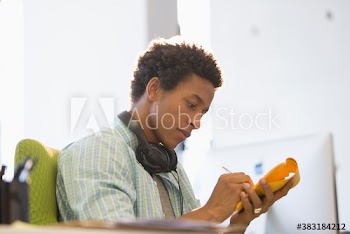 Creative young businessman with headphones brainstorming in office