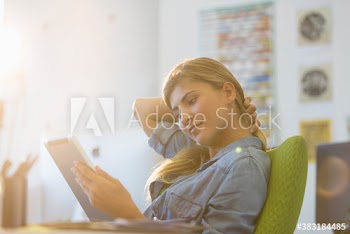 Creative young businesswoman using digital tablet in office