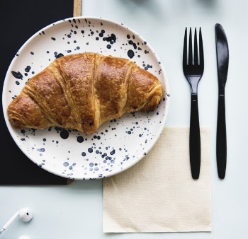 Croissant Bread on Plate With Fork and Knife Beside