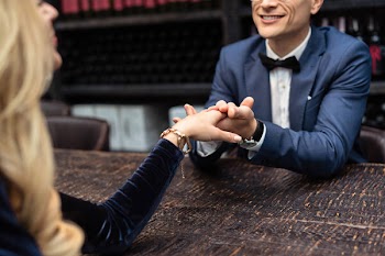 Cropped shot of couple having date at restaurant and holding hands