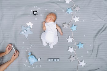 cropped shot of mother taking picture of sleeping baby on smartphone