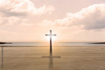 Cross religion symbol shape over sunset sky at the beach