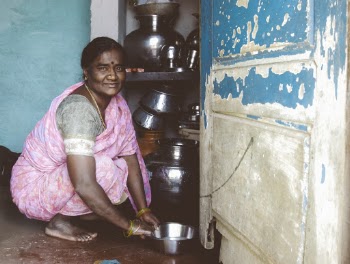 Crouching and Smiling Woman Wearing Pink Sari Dress Holding Gray Stock Pot