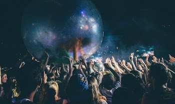 Crowd of People Passing Big Rubber Ball with Person Inside