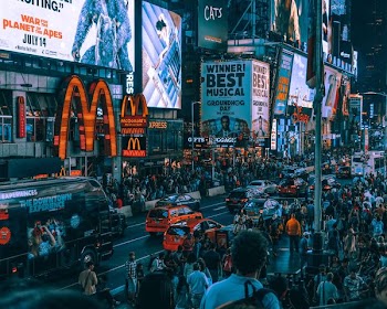 crowd of people waking on street in front of McDonald's building