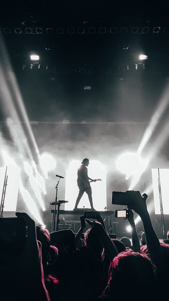 Crowd of People Watching a Man Perform on Stage