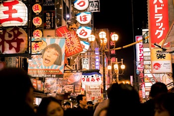 Crowd Surrounded by Buildings during Night Time