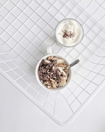 Crushed Nuts and Chocolates on White Ceramic Mug High-angle Photography