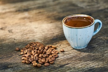 Cup Of Coffee Beside Coffee Beans