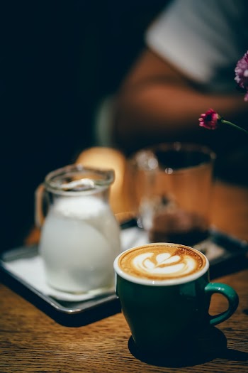 Cup of Coffee Latte Near Cream Pitcher
