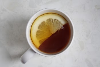 Cup of Tea With Sliced Lemon on White Surface