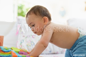 Curious baby boy playing with toys