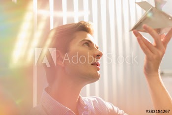 Curious young creative businessman examining orb