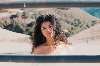 Curly Haired Girl Across Brown Hills