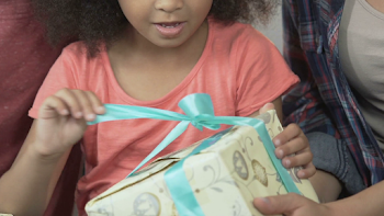 Curly small girl unwrapping Christmas present box, family ...