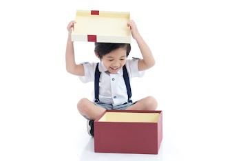 Cute Asian child opening gift present box on white background isolated
