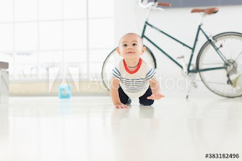Cute baby boy crawling on floor