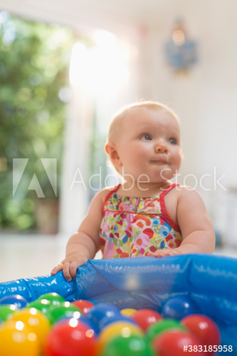 Cute baby girl playing with colorful balls