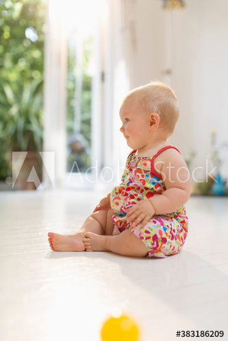 Cute baby girl sitting on floor