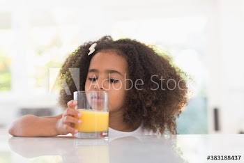 Cute girl drinking orange juice