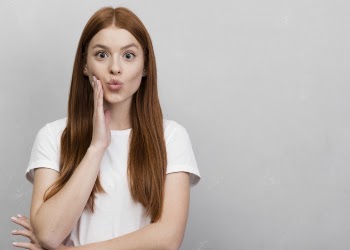 Cute woman puckering lips studio shot Free Photo