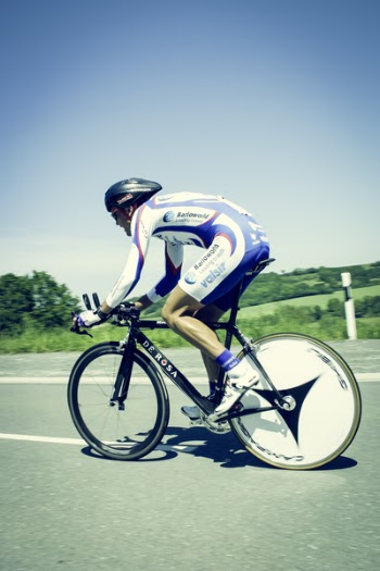 Cyclist on Gray Asphalt Road Under Blue Sky at during Daytime