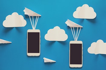 Data transfer concept. Message passing. Two mobile smartphones and paper airplanes on blue background. Origami. Paper cut. Toned