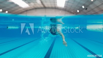 Dedicated female swimmer swimming underwater in swimming pool