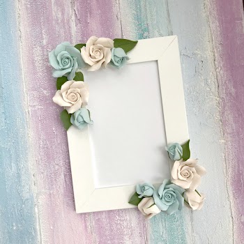 Delicate frame for congratulations or photos on a colored wooden background