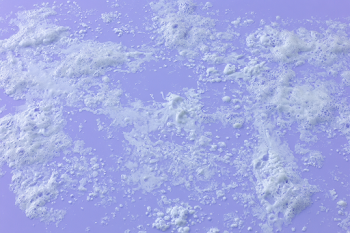 Delicate White Soap Foam on Pastel Lavender Surface