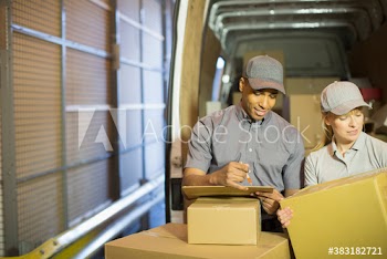 Delivery people checking boxes outside delivery van