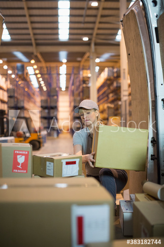 Deliverywoman with boxes inside delivery van