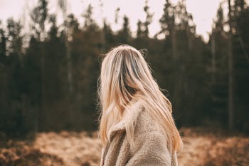 Depth of Field Photography of Woman Wearing White Coat Near Trees