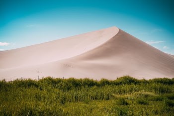 desert mountain near green field