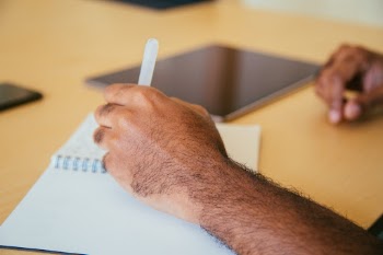 Designer writing notes at his desk