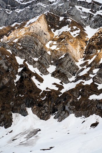 detail view of the stone structure of a mountain range in Switzerland during spring with left over snow
