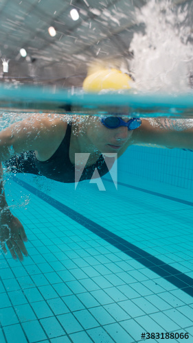 Determined female swimmer swimming underwater in swimming pool