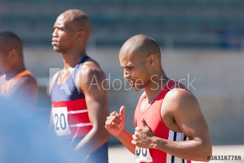 Determined male track and field athlete on sunny running track