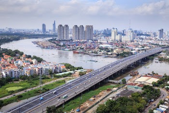 Different Vehicles on Road Near High-rise Buildings Showing Bridge and Sea