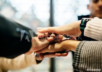 Diverse people stacking hands together