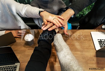 Diverse people stacking hands together