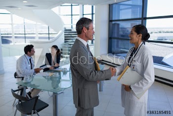 Doctor and hospital administrator shaking hands