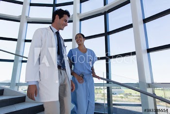 Doctor and nurse talking on modern hospital staircase