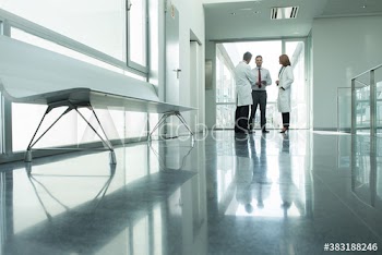 Doctors and administrator talking in hospital corridor