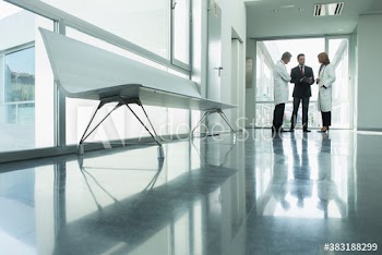 Doctors and administrator talking in hospital corridor
