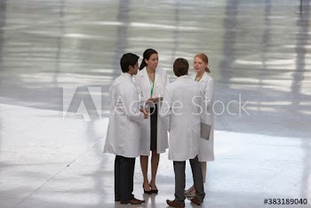Doctors in lab coats consulting in circle