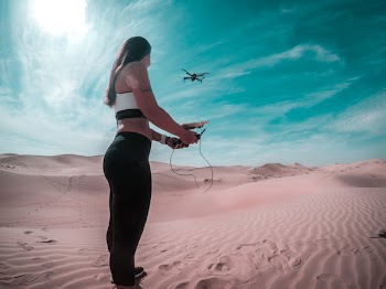 Drone on Mid Air While Woman Holding Controller