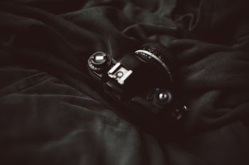 DSLR camera on top of black blanket