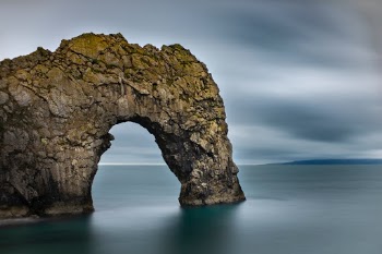 Durdle Door

Durdle Door (sometimes written Durdle Dor) is a natural limestone arch on the Jurassic Coast near Lulworth in Dorset, England.
It is privately owned by the Welds, a family who owns 12,000 acres (50 km2) in Dorset in the name of the Lulworth Estate. It is open to the public. The name Durdle is derived from the Old English word ‘thirl' meaning bore or drill.
- Wikipedia - 