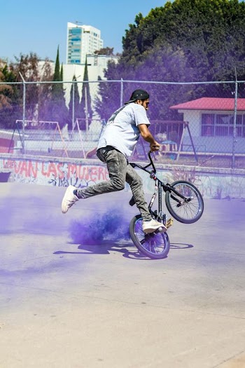 Dynamic BMX Rider Performing Stunt with Colorful Smoke